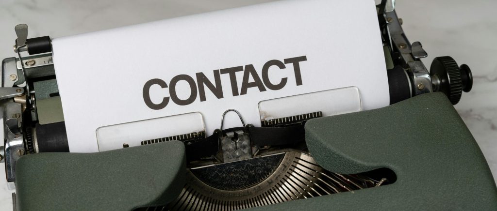 Machine à écrire avec le mot contact sur une feuille